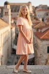 Dívčí šaty Sia růžové – celá postava na pozadí věže starého města